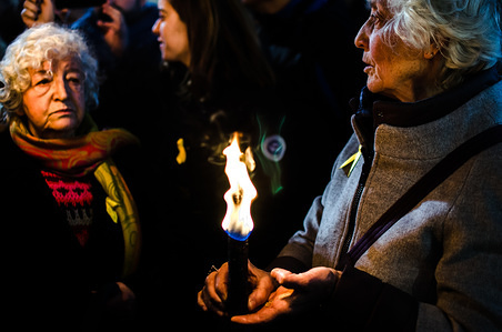 A woman holds in hands a flaming torch while another woman watch her during a demonstration.
Hundreds of people demonstrated in a Traditional March with torches asking for the freedom of all the pro independence and anarchist political prisoners in Spain.