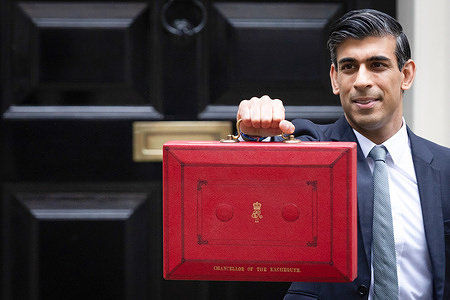 Chancellor of the Exchequer Rishi Sunak displays the red budget briefcase to the waiting media in Downing Street ahead of the Autumn Budget.
