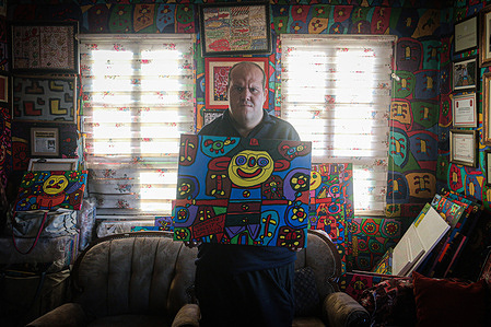 Muhammed poses for a picture with his favorite work.
Muhammed Yalçın, a mentally disabled painter, lives in Ankara, Turkey. He went to a special education school for the handicapped for two months in 2009. During that time, he discovered his passion. He lived with his family in their shanty house and has painted the whole house as a canvas to express his imagination.