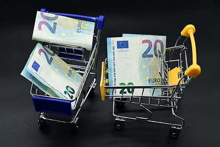 Twenty euro banknote seen displayed in shopping trolleys on a black background.