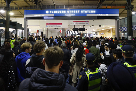A large crowd gathers around Flinders Street Station, people chatting excitedly after the New Year fireworks display. After the spectacular New Year’s fireworks, the crowd flows toward Flinders Street Station, heading home as the celebrations wind down.