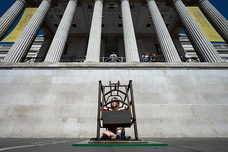 Animal Rising campaigner Michelle Farnham sits inside a pig farrowing crate outside the National Gallery in Trafalgar Square during a protest against intensive pig farming. Farnham plans to remain inside the crate for 21 days and nights to highlight the conditions in which sows are confined on UK pig farms.