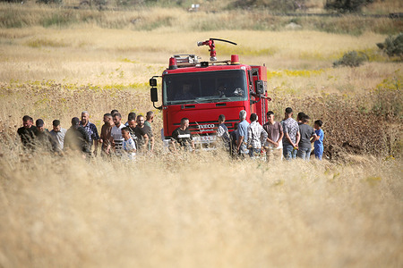 Palestinian farmers protect their crops in the plains of Salem village, east of Nablus in the West Bank. Clashes broke out between Palestinian farmers and Jewish settlers who attempted to set fire to the crops. The Israeli army fired tear gas to disperse the clashes in the plains of Salem village, east of Nablus in the West Bank. Israeli firefighters are working to extinguish the fires, while Palestinian firefighters are preventing them from approaching the area.