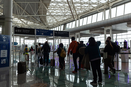 A departures board and global time‑zone clocks dominate the terminal during peak holiday travel at Porto Airport.