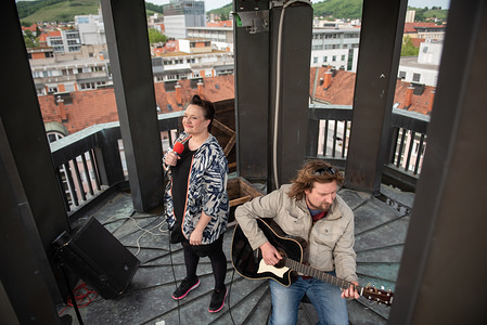 MARIBOR, SLOVENIA - MAY 13, 2020: Slovenian musician Bilbi performs on the tower of the Narodni Dom during the Coronavirus (Covid-19) pandemic. Because of the measures against the spread of the coronavirus, Narodni Dom Maribor organizes concerts on the tower of Narodni Dom, which are streamed live on social media.