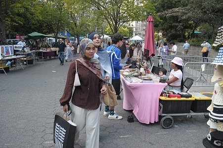 People walk past vendor stands in Union Square, Manhattan, New York City.