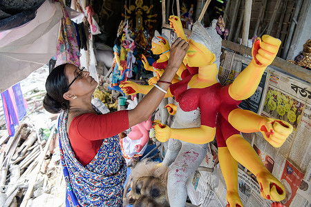 A woman artisan, making final touches to an idol ahead of Durga puja festival.
It is one of the most popular festivals celebrated in honour of Goddess Durga the period of Navaratri. It is celebrated for 10 days, however starting for 6th and 9th day, the Puja is celebrated in full phase.