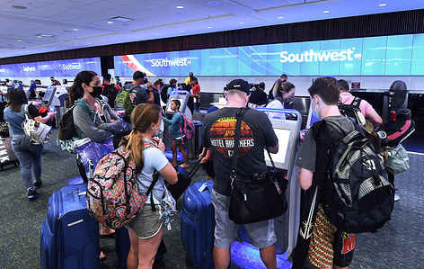 Travelers check in for a Southwest Airlines flight at Orlando International Airport as the July 4th holiday weekend begins. Americans are expected to travel in record numbers over the Independence Day holiday.