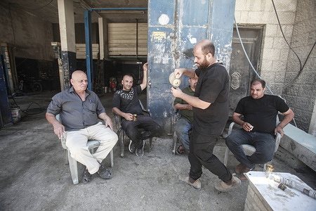 Palestinians drink coffee in front of their destroyed shop inside the market in Nour refugee camp as residents return to the camp after Israeli forces demolished more than 48 buildings in the camp, located east of Karm Tul, in the northern West Bank. This comes 100 days after the dynamic Freedom Gate military operation, in the northern West Bank camps, known as "Operation Iron Wall."