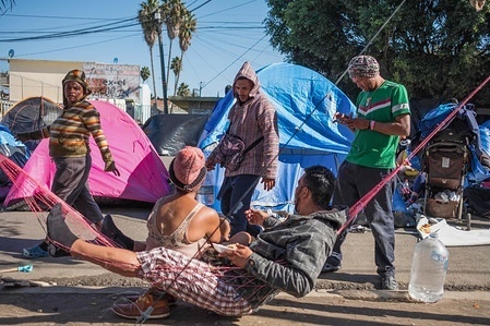 Members of the migrant caravan are seen resting in a makeshift camp as they wait to apply for asylum in the United States.
Around 6,000 migrants are staying in the camp.