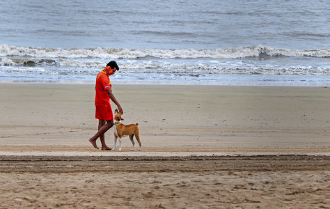 A lifeguard along with a dog patrol the beach in preparation for the cyclone.India Meteorological Department (IMD) says that tropical cyclone isarga?has headed for the Maharashtra coast. People have been advised to stay indoors, be prepared to face possible power cuts as strong winds hit the city. National Disaster Response Force (NDRF) has positioned nine teams in vulnerable districts.