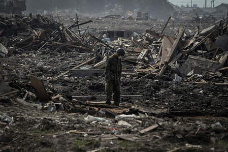 Japanese Self Defense Force members clear debris looking for bodies in Senday. The country marks four years since the earthquake tsunami and nuclear disaster. Damaged buildings and scattered debris are visible in Ishinomaki, a coastal city in northeast.
