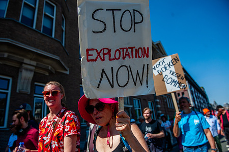 A woman seen holding a placard against working exploitation during the demonstration. On International Workers' Day, people marched in Amsterdam to demand a living income for everyone.