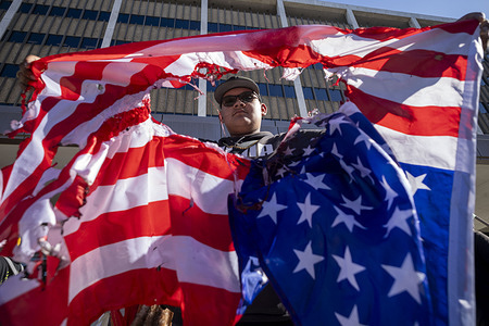 A protester holds a burned American flag outside the Federal Building in Los Angeles on Feb. 13, 2026, during a student-led demonstration against Immigration and Customs Enforcement. Students from more than 10 high schools walked out of class and converged on the downtown building as part of a coordinated citywide action.