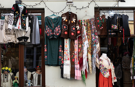 Traditional embroidered clothing seen hanging for sale on a storefront, these garments represent local cultural heritage and craftsmanship. Lviv street scene