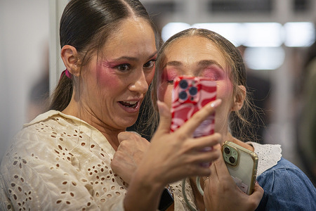 Two models film a video backstage at the Spring/Summer 2026 collection show at the 40th Mercedes-Benz Fashion Week Madrid.
