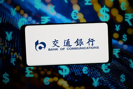 In this photo illustration, the logo of Bank of Communications Co. Ltd. (BankComm) is displayed on a smartphone in front of abstract background on computer screen.