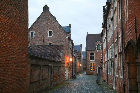 A street in the Great Beguinage of Leuven, is seen at dusk. The Beguinage was founded in the early 13th century, as a community for Beguines, who were unmarried, semi-religious women.