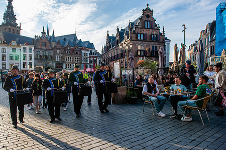 A music band is seen leading the procession. On this day, around the whole country, ceremonies are held to commemorate the civilians and soldiers around the world who were killed during World War II and other conflicts. In Nijmegen, a ceremony took place inside St. Stephen's Church, from there a silent procession took to the streets to the "Keizer Traianusplein", where two monuments in remembrance of the victims of WWII stand. The official ceremony started with two minutes of silence, after that, the Mayor of Nijmegen Hubert Bruls, gave a speech remembering the victims, and wreaths were laid close to the monument.