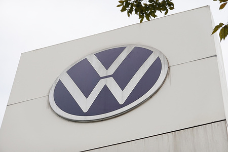 The Volkswagen logo is displayed on a white building structure.