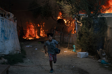 A child flees the Moria refugee camp after fires completely destroyed the camp on Wednesday.
Thousands of people have been forced to flee their homes after a fire broke out in Moria camp destroying their homes and belongings.