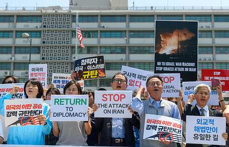 Activists from civic groups hold placards during a press conference in front of the U.S. Embassy to protest the U.S. military attack on Iran.