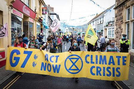 Protesters march with a banner through St Ives village near where delegates are meeting for the 47th G7 during the demonstration.
The Extinction Rebellion movement descend onto the small Cornish seaside town. Hundreds of protesters march through the village near where delegates are meeting for the 47th G7. The event sees world leaders come together to discuss matters around climate change.