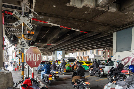 A view of a road in Phaya Thai District with heavy traffic crossing the railway track.