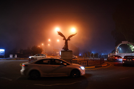 Cars seen driving through foggy weather.