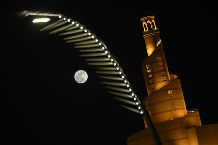 The full moon, known as the Blue Moon, is seen behind the Al Fanar Masjid in Doha.