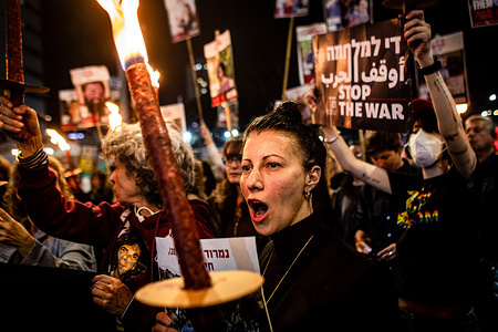 A protester chants calling for the release of all hostages during a protest in Tel Aviv. Israel and Hamas have agreed to a 42-day ceasefire, involving the release of 33 hostages by Hamas in exchange for 1,000 Palestinian prisoners. This development follows 15 months of conflict that began on October 7, 2023.