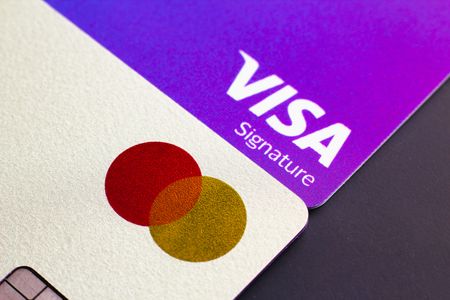 A close-up view of Visa Signature and Mastercard credit card and a debit card seen displayed.