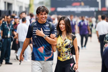 Alex Albon (L) of Atlassian Williams F1 Team and partner He Muni "Lily" (R) in the paddock ahead of the F1 Grand Prix of Singapore at the Marina Bay Street Circuit in Singapore, Singapore.