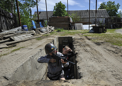 Ukrainian children play territorial defense fighters patrolling in the village of Stoyanka, Kyiv region.