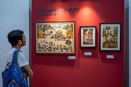 A visitor observes tribal paintings from Jadupatua Art showcased during the Tribes Art Fest 2026. Jadupatua Art is a traditional tribal scroll painting from Jharkhand, created by the Jadupatua community. Tribes Art Fest 2026, organized by the Ministry of Tribal Affairs, is being held at Travancore Palace on K.G. Marg in New Delhi. The 12-day festival celebrates tribal art and culture, featuring over 30 tribal art forms, 70 artists, and more than 1,000 artworks. Contemporary artists also collaborated with tribal artists, creating works that blend traditional knowledge with modern artistic practices.