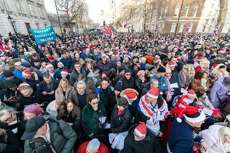 A large crowd is gathered by the stage. Christian worshippers gathered in Whitehall, for a public faith rally organised by Unite The Kingdom and co-organised by activist Tommy Robinson, calling to “put Christ back into Christmas.” The event featured Bible readings, prayers, live worship music, and personal testimonies, with organisers presenting the gathering as a peaceful celebration of Christian belief and unity rather than a political demonstration.