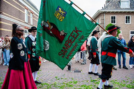 A man is carrying the flag of a small village called Sambeek during the ceremony. The "Boxmeerse Vaart" is an ancient Holy Blood procession. According to the story, a priest doubted the conversion of bread and wine into the body and blood of Christ; after that, the blood turned back into wine.