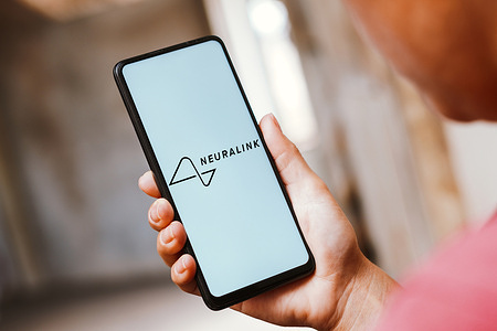 In this photo illustration, the Neuralink logo is displayed on a smartphone screen.