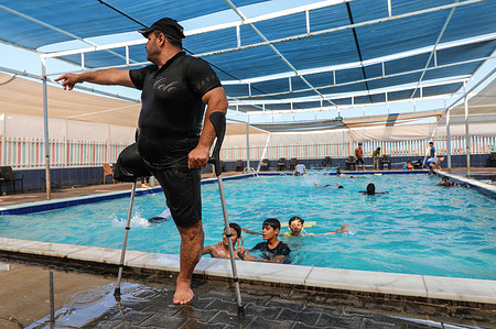 Palestinian swimming coach Majdi El-Tattar gives some tips to the children as he trains them on swimming at a local pool in Gaza. Majdi Al-Tattar, 37, is a one-footed swimming coach. He lost his leg due to a traffic accident two decades ago. He founded the Palestine Swimming School five years ago and is still striving to develop his school into a great academy that graduates champions who can participate in international swimming championships.