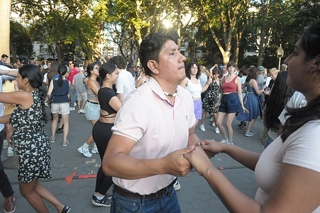 People dance in a salsa dance event in Washington Square Park, Manhattan, New York City.