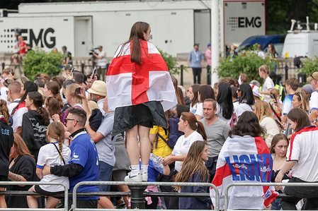 A football fan with St George's flag wrapped around during the Lionesses open-bus parade on the Mall to Queen Victoria Memorial. England defeated Spain 3-1 on penalties.