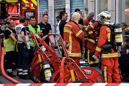 Firefighters are seen on the street during an apartment fire in Marseille. A fire destroyed an apartment on the fourth floor of a building on rue de la Palud in downtown Marseille that was set by a man in his apartment following a marital dispute.