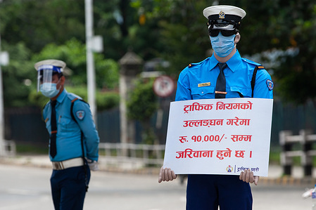 A policeman wearing a face shield stands next to a masked mannequin wearing an outfit of traffic police and holding a prevention placard along the empty road during the 12th day of the second lockdown as a preventive measure against the spread of Coronavirus pandemic in Nepal.
Nepal police place 22 mannequins dressed like traffic police to curb traffic violations amid coronavirus pandemic.