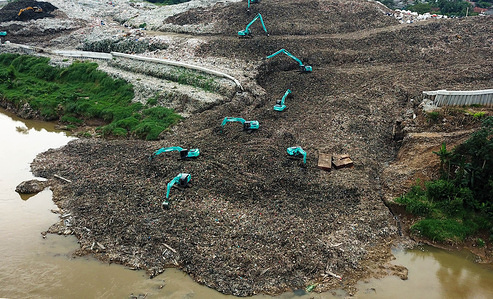 (EDITOR’S NOTE: Image taken with a drone)
Aerial view of heavy equipment (excavators) working on waste falling into the Cisadene River due to landslides at the landfill.
As a result of exceeding the capacity, the Cipeucang landfill (TPA) has spilled almost throughout Cisadane River which is around the location. The pandemic has also increased waste production from the household sector and the composition of plastic waste. Global plastic production has quadrupled over the past four decades.