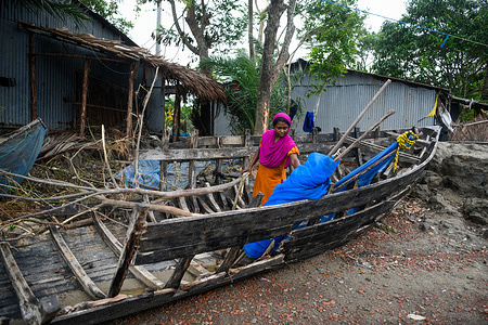 A woman observes her broken boat during the aftermath in Mongla. Cyclone Remal, which originated in the Bay of Bengal, struck the southern coastal districts of Bangladesh on the night of Sunday, May 26th. The cyclone brought with it devastating wind speeds of 90 to 120 km/h, resulting in extensive flooding and destruction. The Sundarbans, a critical natural barrier and UNESCO World Heritage site, bore the brunt of the cyclone's impact. Floodwaters surged three to four feet above normal, submerging vast areas and causing significant damage to wildlife and infrastructure, including the Karamjal Wildlife Breeding Center and numerous patrol posts. In the coastal districts of Bagerhat, Satkhira, Khulna, Patuakhali, and Barguna, thousands of homes were destroyed, leaving around 50,000 families waterlogged and without electricity. The humanitarian crisis is compounded by environmental concerns, such as the loss of wildlife and the disruption of freshwater sources.