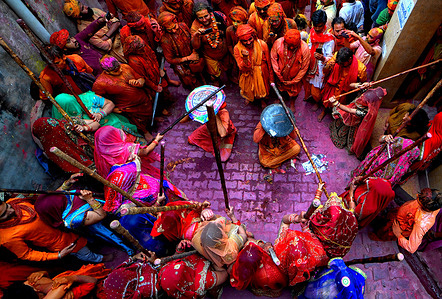 Hindu men are being ritually beaten with sticks (Lathi) during the Lathmar Holi Festival.
The Lathmar Holi festival is based on a Hindu legend, according to which Lord Krishna travelled from his home village of Nandgaon to Barsana to tease his lover Radha. Radha and her entourage took offense at his advances and drove Krishna out of the village. Today the legend is celebrated at the Radha Rani temple in Barsana. Each year, men from from Nandgaon travel to Barsana where they are greeted by women wielding lathis (sticks) - hence the name Lathmar holi. The festivities last for over a week during which participants throw coloured powders and liquids at each other and drink copious amounts of a traditional brew called Thandai.