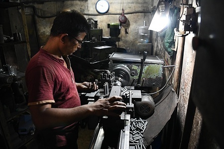 A worker on a lathe machine making vehicle parts at Dholai Khal.
About 200 vehicle scrap shops with thousands of workers are found in Dholai Khal where tons of vehicle garbage are sold to small scale workshops every day. Recently this market has started producing new vehicle parts.