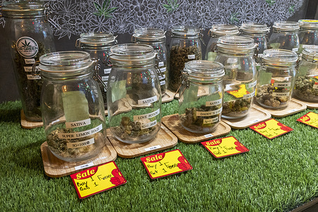 A cannabis shop in Bangkok displays a "buy one get one" sign in front of the store and the products. The Ministry of Health will announce a new regulation on controlled herbal medicine that limits the use of cannabis flowers to those prescribed by a doctor.