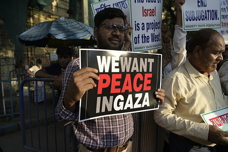 A man holds a placard that says " We want Peace in Gaza" during a demonstration. Members of the All Bengal Minority Youth Federation (MYF) staged a protest in solidarity with Palestinians in Kolkata.