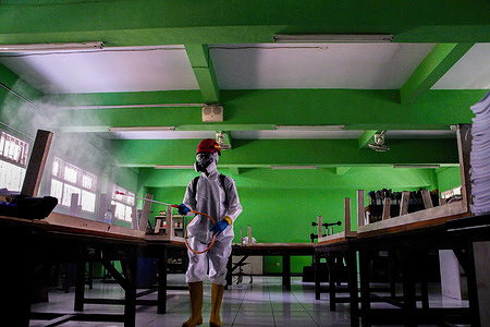An Indonesian Red Cross Officer (PMI) sprays disinfectants inside a classroom at SMKN 7 Jakarta school.
The disinfectant spraying program is implemented in several schools in Jakarta, one of which is at SMKN 7. This program aims to prevent and reduce the spread of the omicron variant of the covid-19, which has continued to increase in recent weeks.